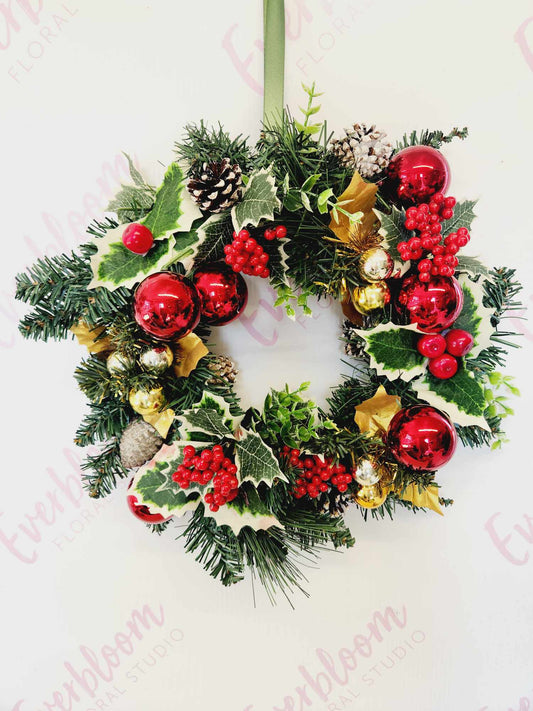 Hanging Faux Red Green and Gold Christmas Wreath with berries, baubles, pinecones and mistle toe.
Everbloom Floral Studio