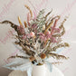 Dried floral arrangement in dusky pinks, natural brown tones with a soft hint of blue created in a white ceramic pot.
Everbloom Floral Studio, Your favourite Papamoa florist