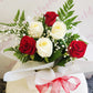 Red and white rose bouquet wrapped in soft white paper in flower bag with red bow. Tauranga Florist - Everbloom floral studio