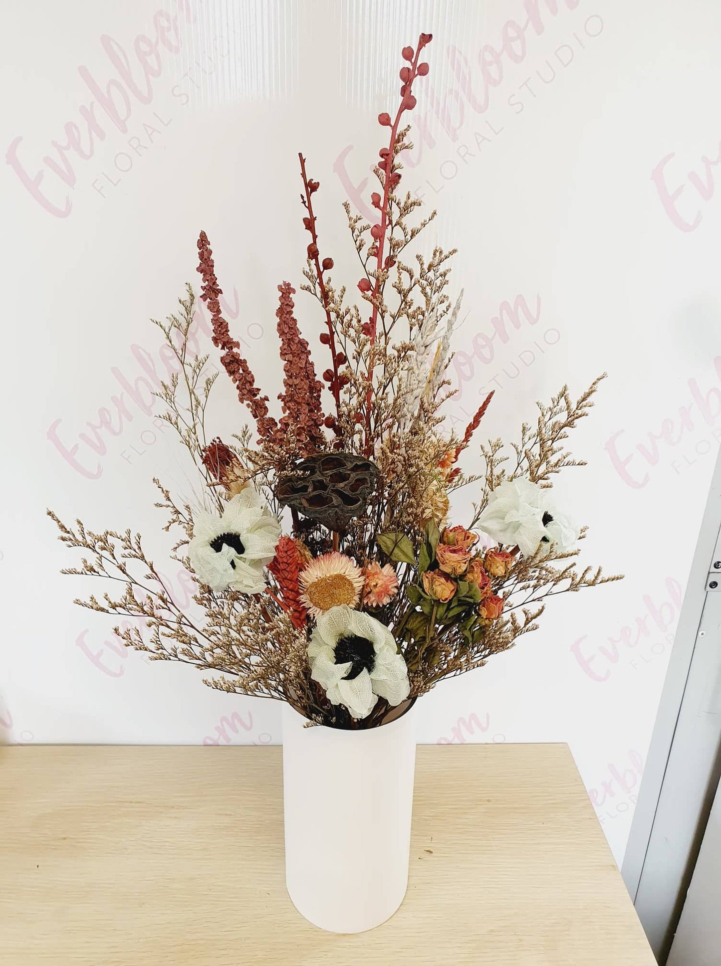 Our dried flower arrangements now come in white vases, Simply receive, display and enjoy, no fuss finding the right height vase for your flowers.  Dried arrangements may slightly vary due to availability and colour but for the most part will stay similar to the pictures provided.  A mix of strawflowers, caspea, spray roses, anenomes, lotus pods and wild flowers.  Same day flower delivery from our sunny mount maunganui floral studio.