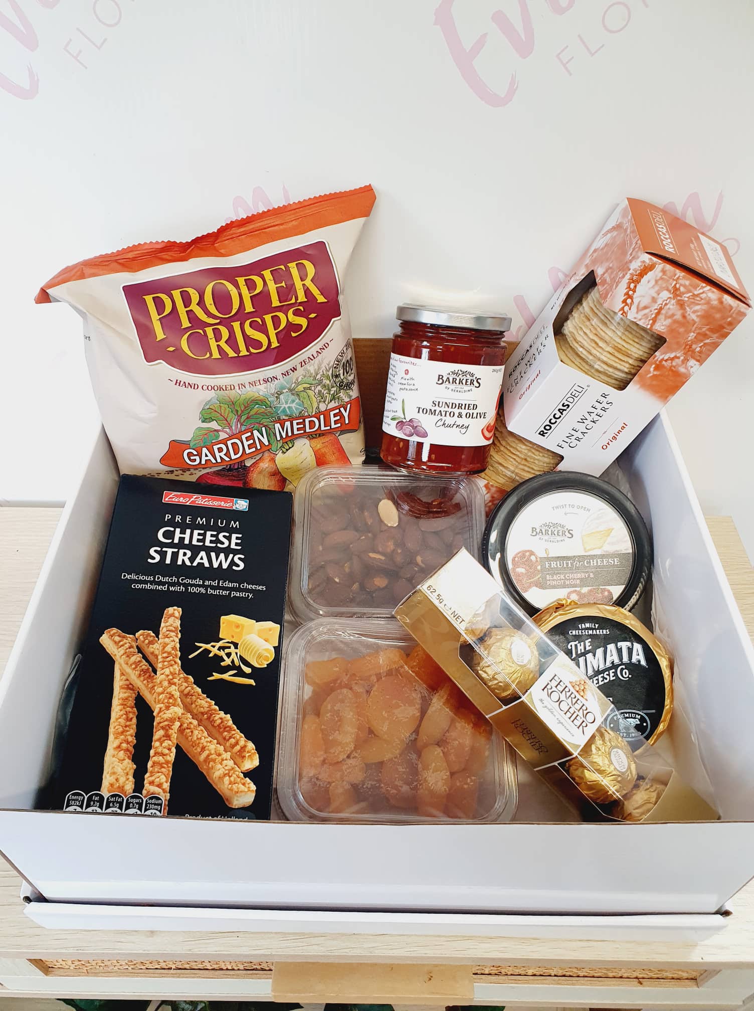 New to our Menu is this snackers delight gift box, packed with delicious nibbles to share with your friends and family. A great picnic pack or pre BBQ platter.  Gift Box includes -   Proper Crisps Garden Medley Chips, Barkers Sundried Tomato and Olive Chutney, Wafers, Cheese Straws, Semi Dried Apricots, Almonds, Black Cherry and Pinot Noir Jelly, Waitemata Cheese and a pack of Fererro Rochers.  Order for your same day hamper and gift box delivery to Papamoa, Mount Maunganui and Tauranga 