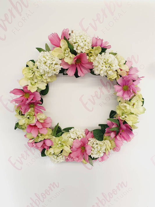 Beautiful real looking silk flowers made into this enchanting hanging wreath. Pink, Green and White flowers. Same day flower delivery from our sunny mount maunganui florist.